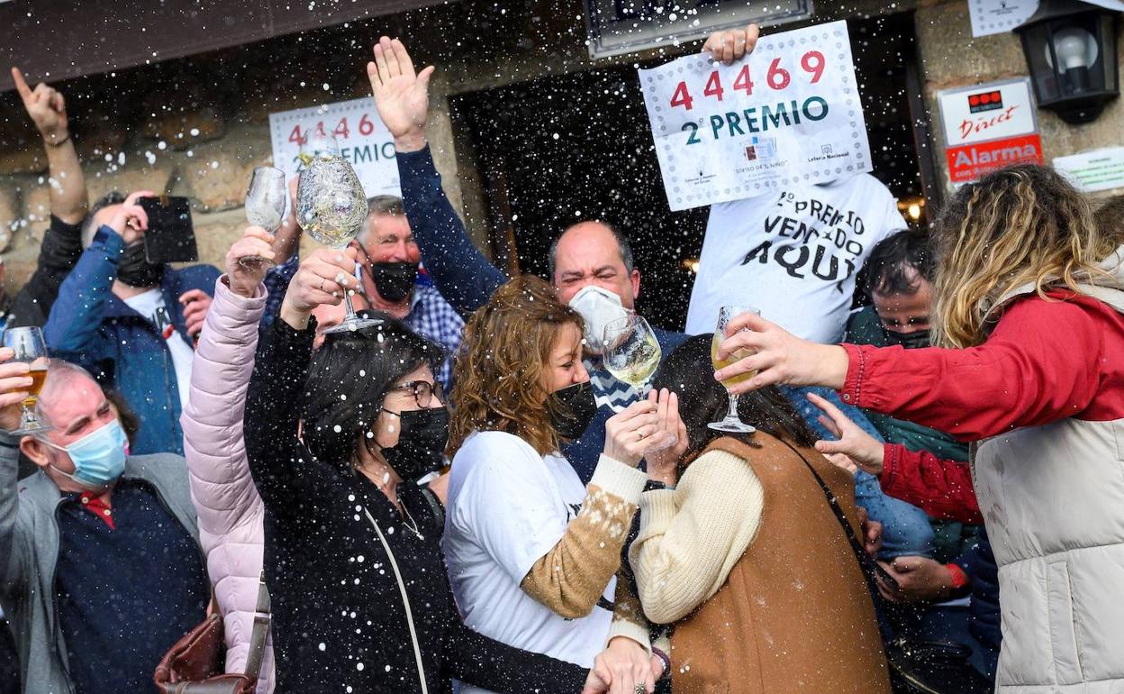 Varias personas celebran parte del segundo premio correspondiente al sorteo de la Lotería de El Niño, este jueves en la localidad cántabra de Treceño.
