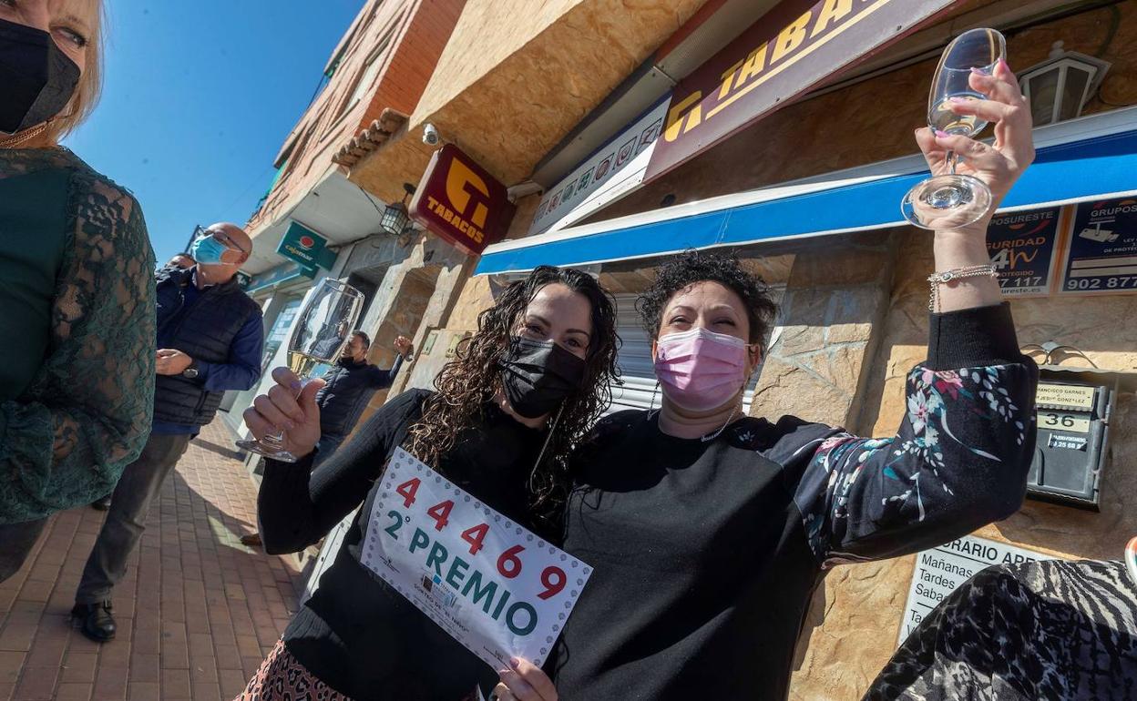 Dos mujeres celebran el segundo premio de la Lotería del Niño.