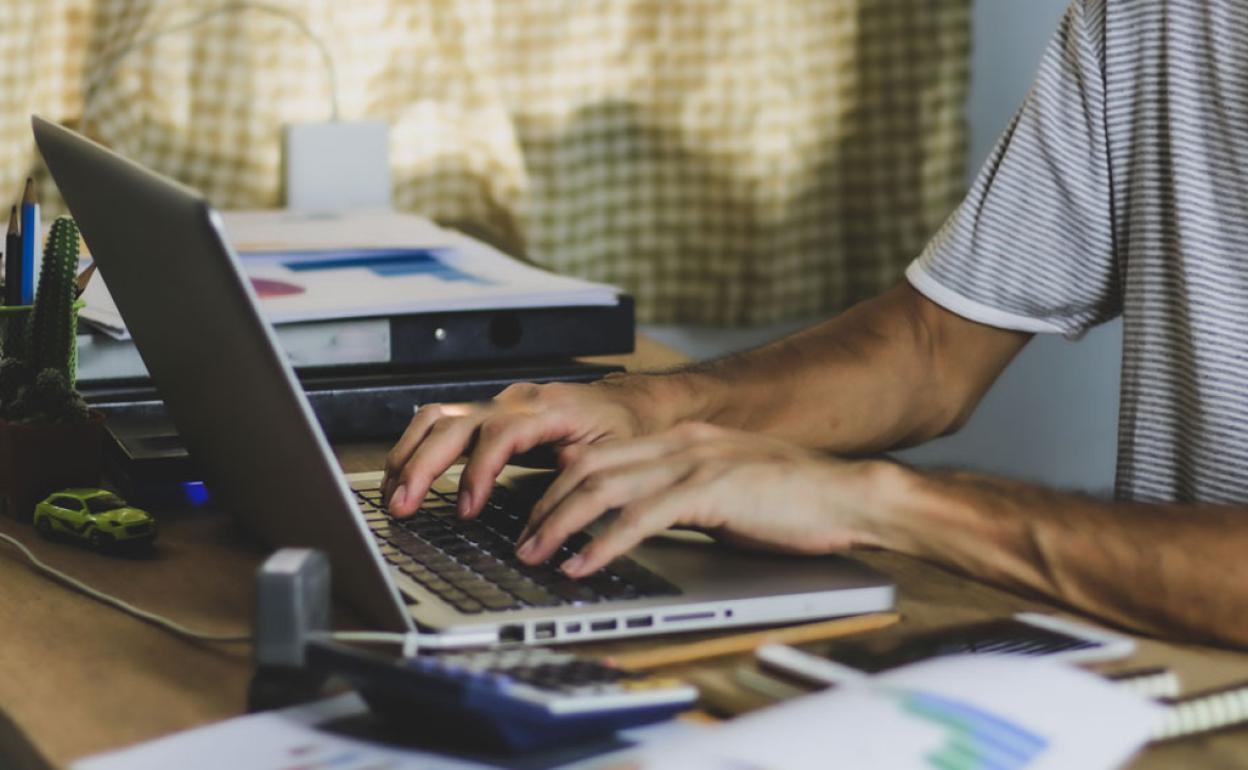 Un hombre realiza un tramite a través de internet. 