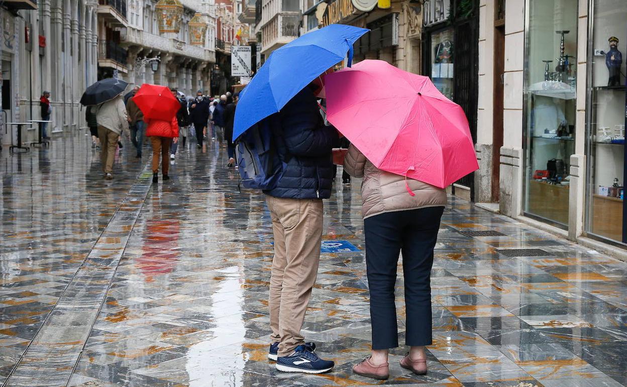 Dos personas se protegen de la lluvia en Cartagena, en una imagen de archivo.