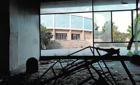 Estructura calcinada de una cama en la cafetería del pabellón residencial; al fondo, la fachada del teatro. 
