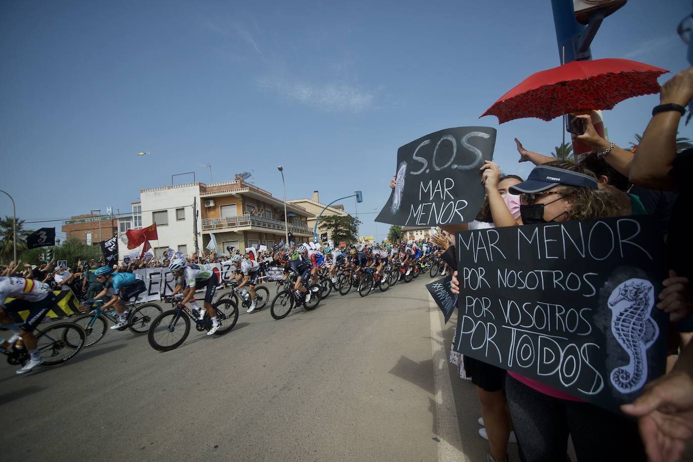 21/08/2021. Las protestas por la laguna llegan a la Vuelta Ciclista. Colectivos vecinales y ecologistas volvieron a salir a la calle el 21 de agosto para visibilizar su lucha en defensa del Mar Menor a nivel nacional e internacional. Aprovecharon el paso de la octava etapa de la Vuelta Ciclista a España por los pueblos del Mar Menor y su llegada a la meta en el kilómetro 10 de La Manga para dar a conocer el «pésimo estado de la laguna» y «exigir medidas urgentes para frenar su degradación», explicó una portavoz de la plataforma que promueve la personalidad jurídica de la laguna a través de una Iniciativa Legislativa Popular (ILP). | NACHO GARCÍA