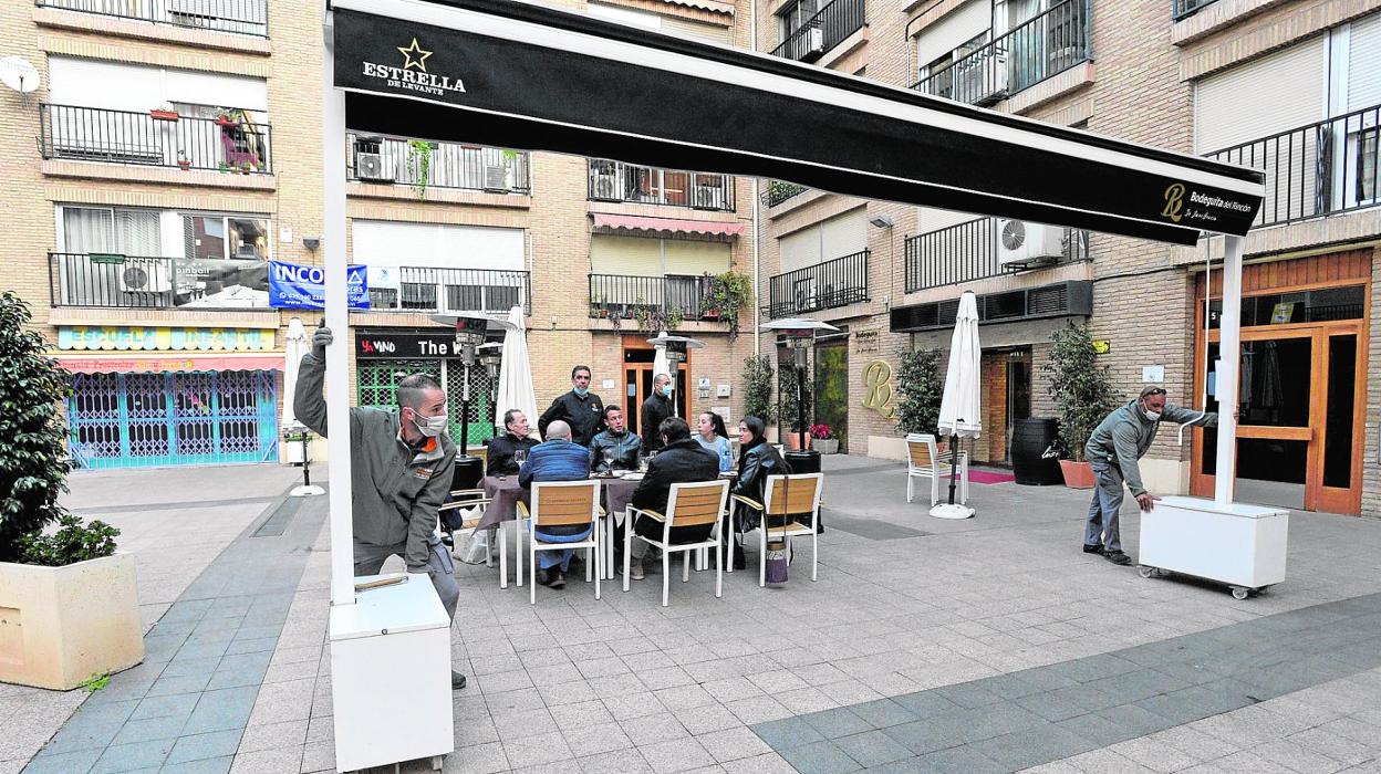 Operarios de la empresa contratada por el propietario de Bodeguita del Rincón, durante la retirada del toldo en la tarde de ayer. 