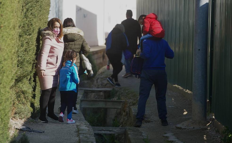 Un grupo de padres lleva a sus hijos al colegio Severo Ochoa de Los Garres a través de una vía para regantes, este miércoles.