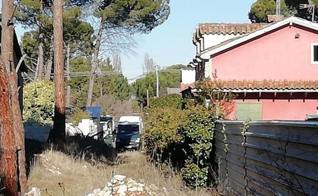 Furgoneta de la Guardia Civil en la urbanización donde se ubica la vivienda que está siendo registrada.