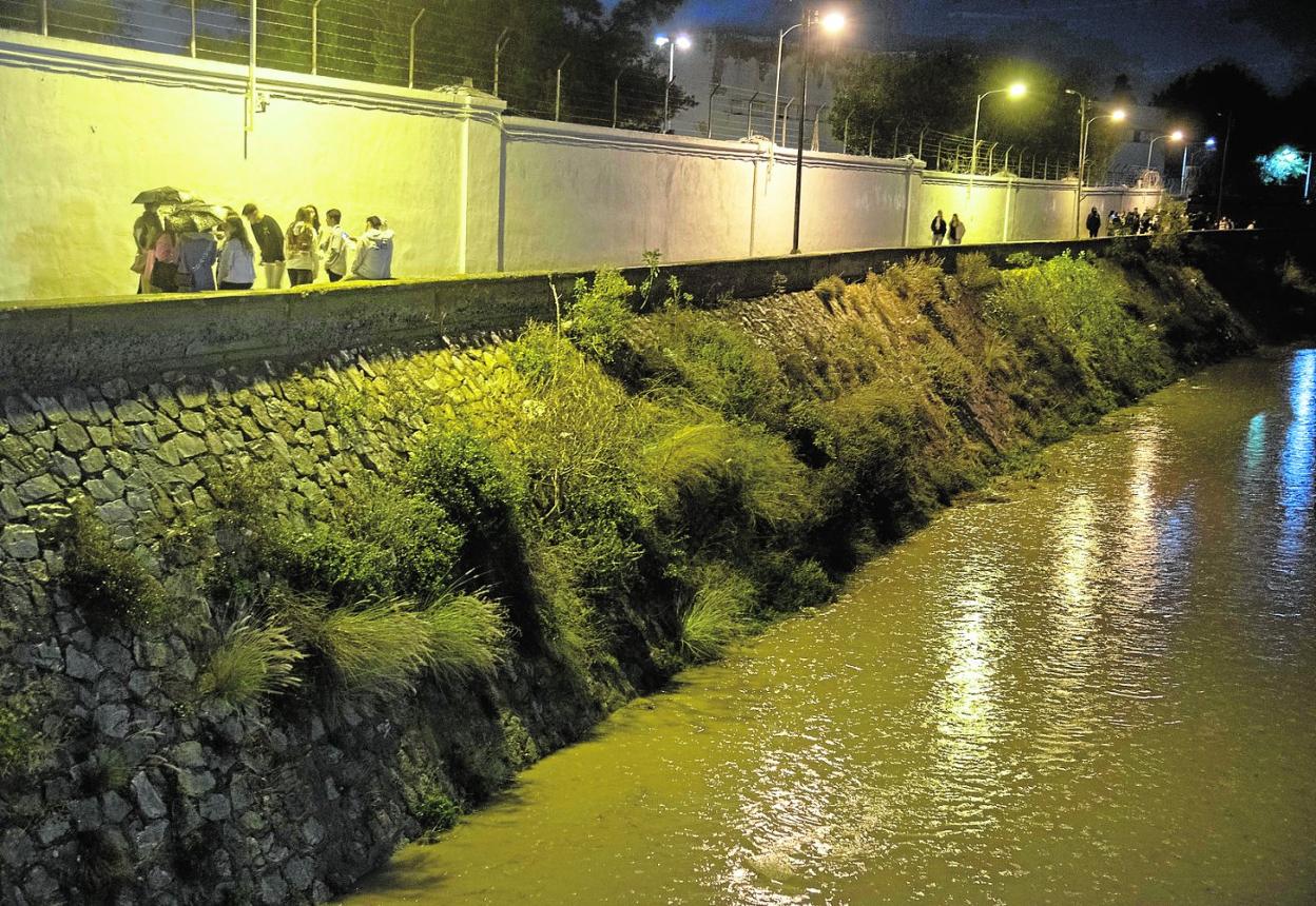 Jóvenes en varios grupos hacen botellón una lluviosa noche del pasado mes de noviembre junto al muro del Arsenal.