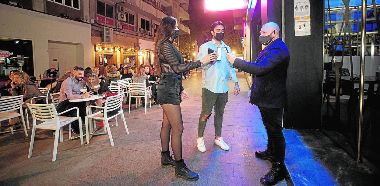 Unos clientes muestran su pasaporte Covid para acceder al bar Lavanna, en la calle Pérez Casas de Murcia. 