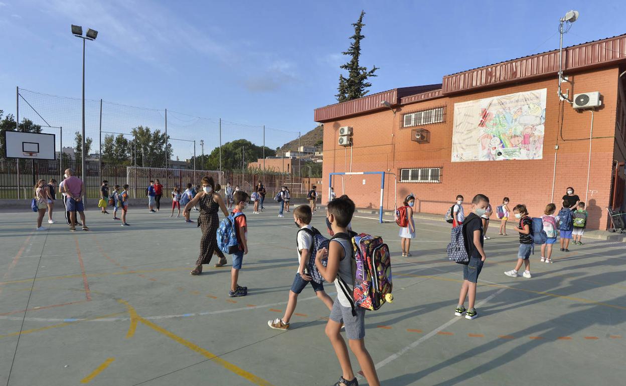 Varios niños portan mascarilla en el patio de un colegio de Murcia, en una imagen de archivo.