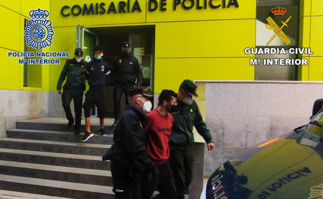Agentes de la Guardia Civil y Policía Nacional con dos de los detenidos.
