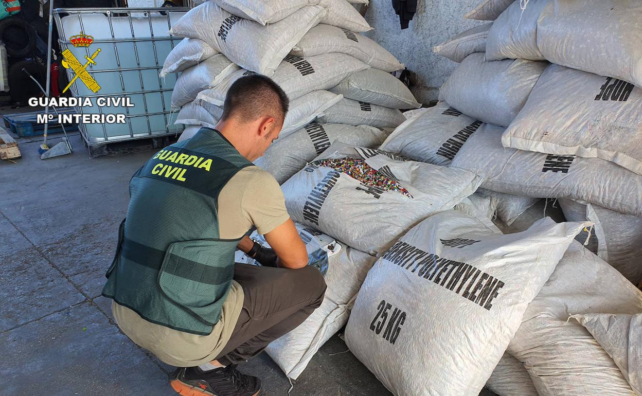 Un agente de la Guardia Civil, junto a varios sacos de escamas PET.
