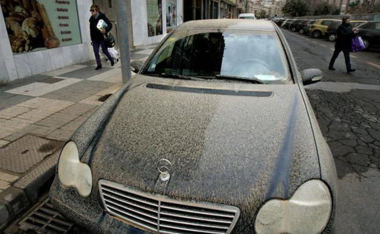 Un coche lleno de barro después de llover.