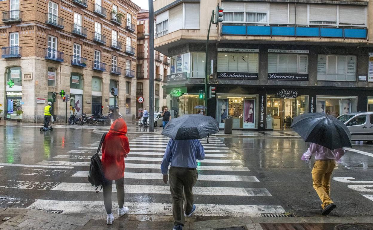 Varias personas se protegen de la lluvia, en una imagen de archivo.