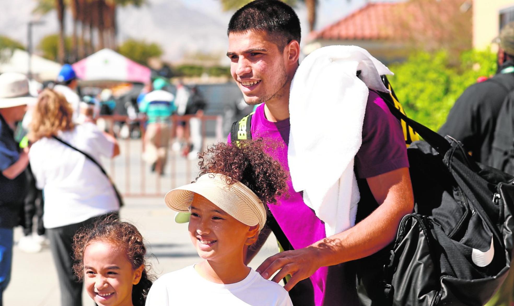 Carlos Alcaraz haciéndose una foto con dos niñas tras su entrenamiento de ayer en Indian Wells. 