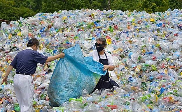 Voluntarios manipulan botellas de plástico en una planta de reciclaje en Taipei. 