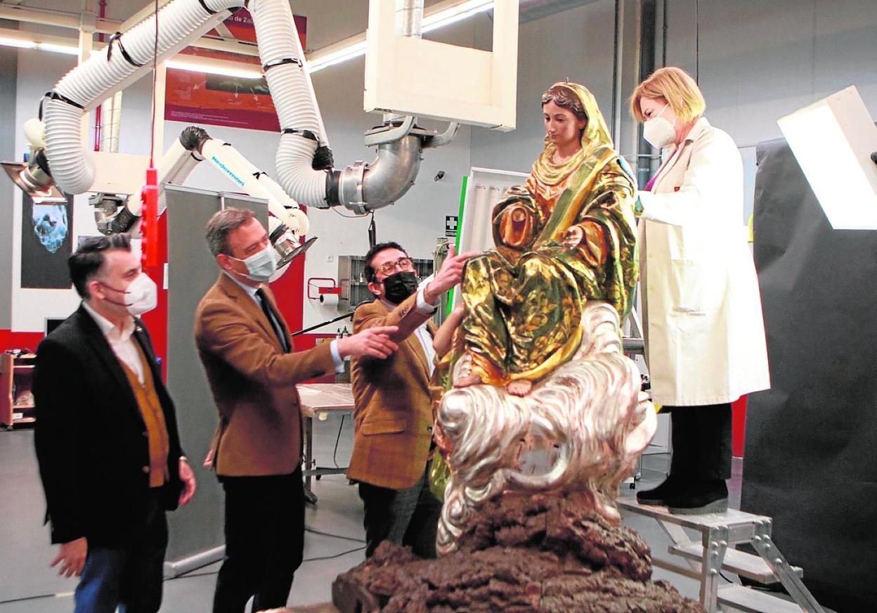 El consejero de Cultura, Marcos Ortuño; el director del Centro de Restauración, Javier Bernal (d), y el secretario de la Consejería, Juan Antonio Lorca, observan la restauración de la imagen de la patrona de El Esparragal. 