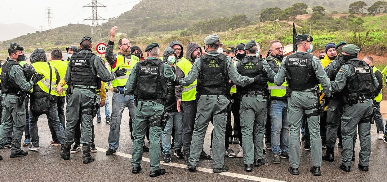 Agentes de la Guardia Civil sujetan a los componentes de un piquete, que querían impedir el acceso de un camión al Valle de Escombreras (Cartagena). 