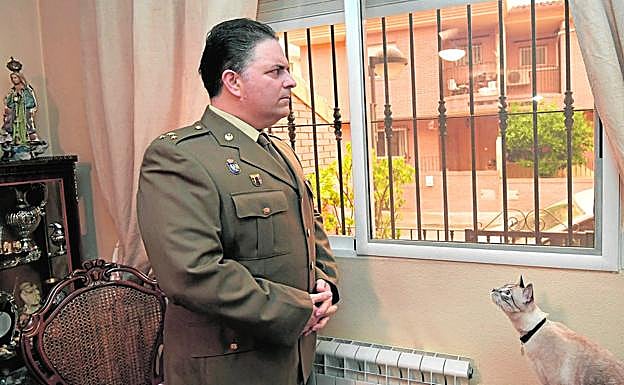 En posición. César Pintado echa un vistazo por la ventana de su casa de La Alberca, bajo la atenta mirada de su gato 'Lindo'. 