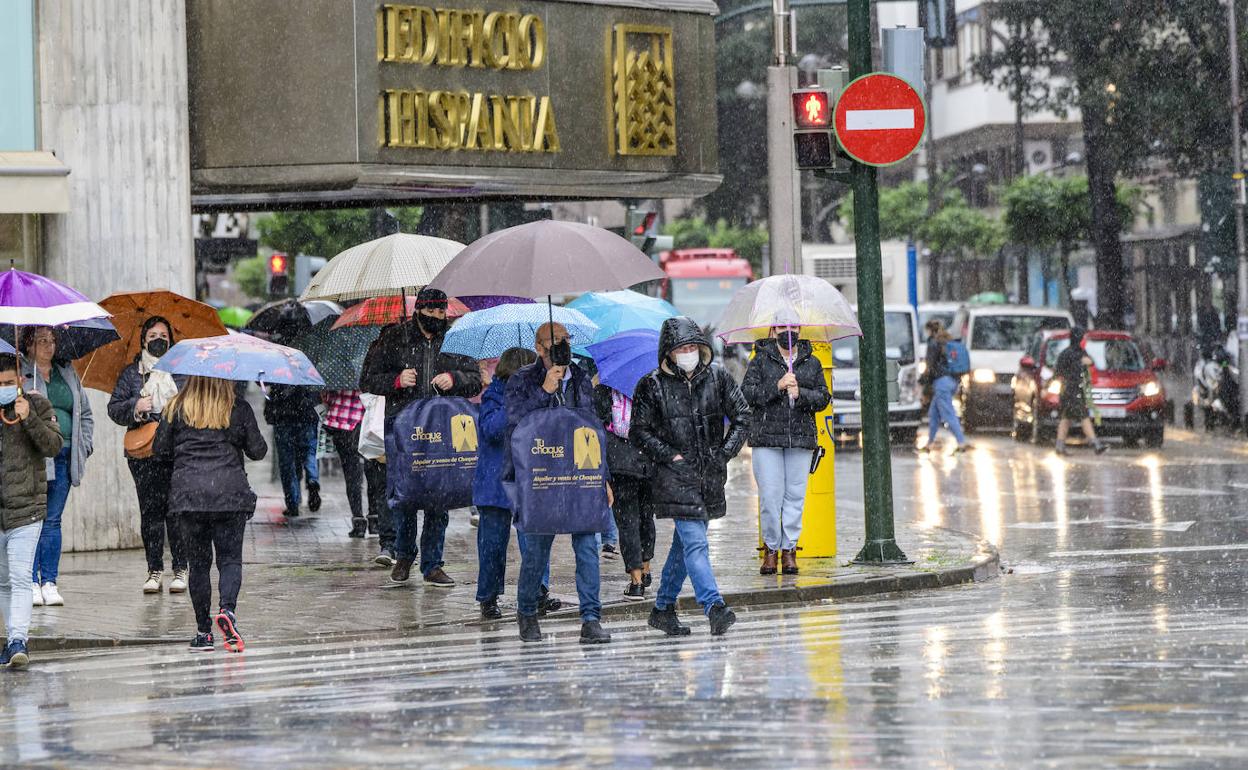Varias personas se protegen de la lluvia en Murcia, en una imagen de archivo.