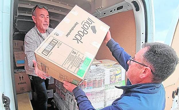 Dos miembros del Club Naútico de Águilas preparan el cargamento.