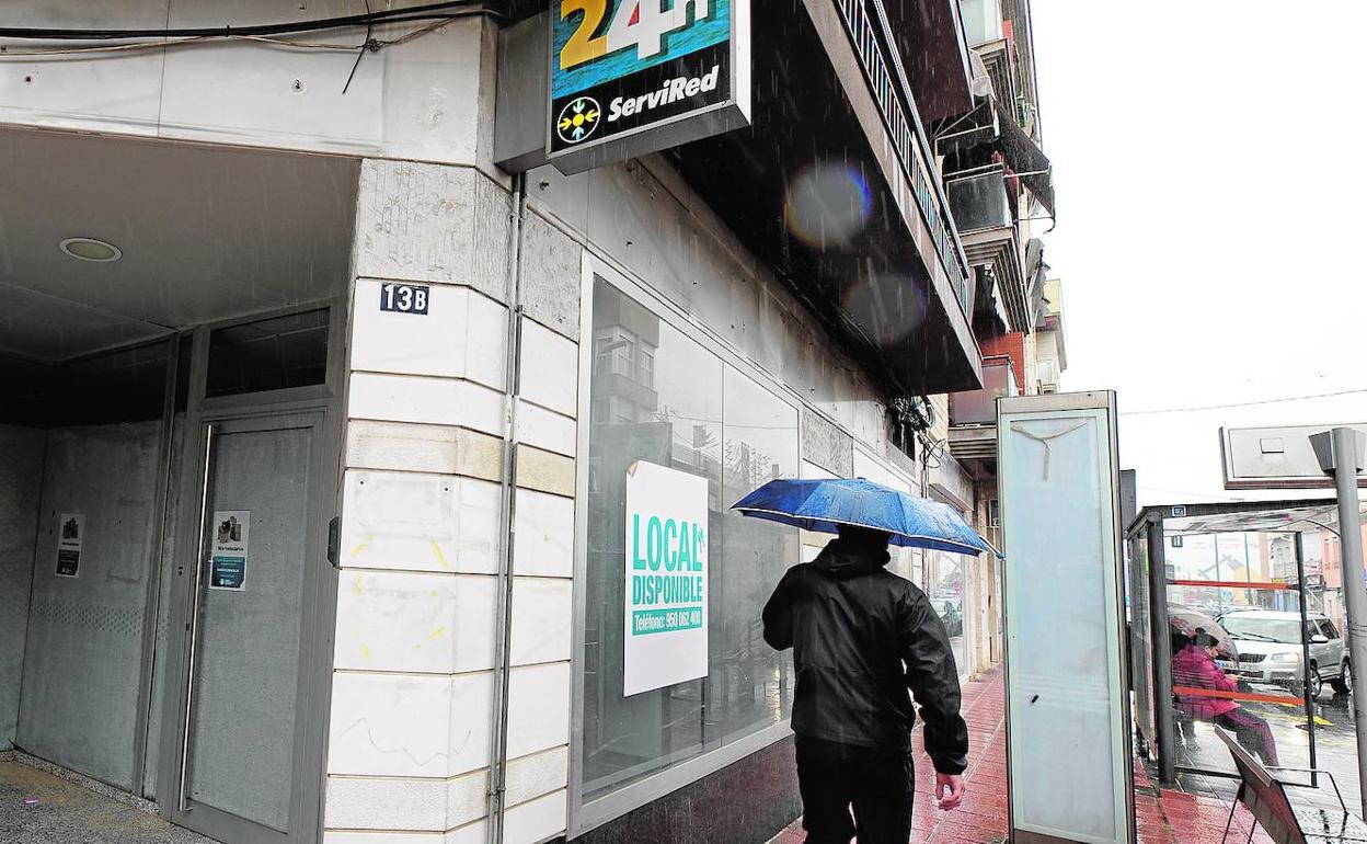 Local de un antigua oficina bancaria en Santiago el Mayor, en Murcia, con el cartel de se alquila.
