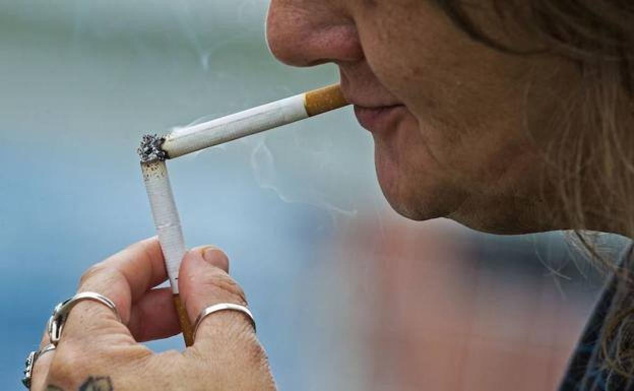 Una mujer encendiéndose un cigarrillo, en una imagen de archivo. 