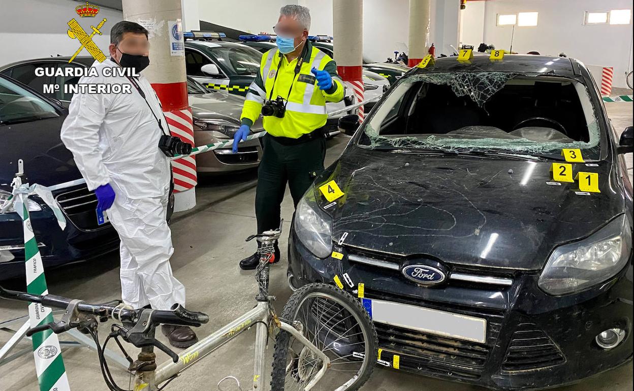 Dos agentes, junto al vehículo del detenido y la bicicleta de la víctima.