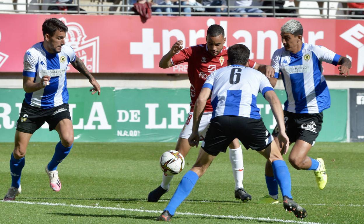 Pablo Ganet intenta regatear a los jugadores del Hércules de Alicante.