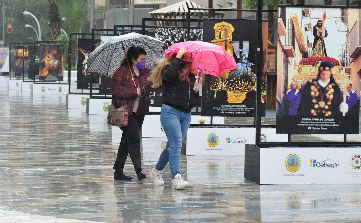 Dos personas se protegen de la lluvia, en una imagen de archivo.