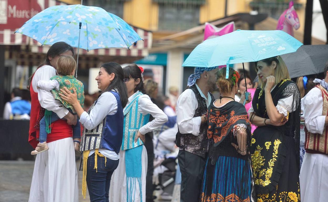 Varias familias vestidas de huertano se protegen de la lluvia en el Bando de la Huerta de 2019.