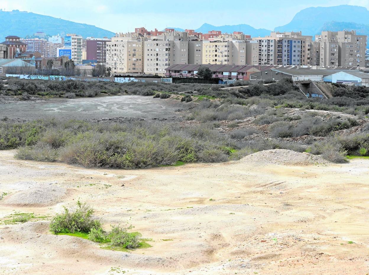 Vista de los terrenos contaminados en El Hondón, con los barrios de San Ginés y del Sector Estación al fondo. La imagen es de archivo. 