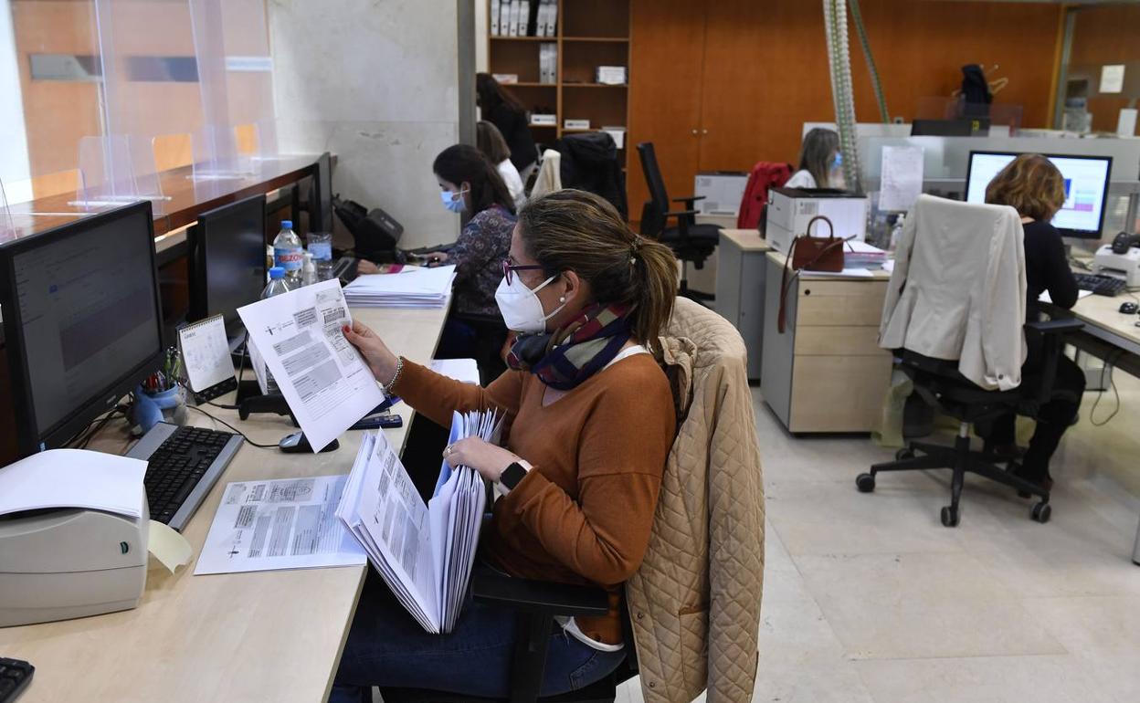 Funcionarios con mascarilla en el trabajo en una imagen de archivo. 