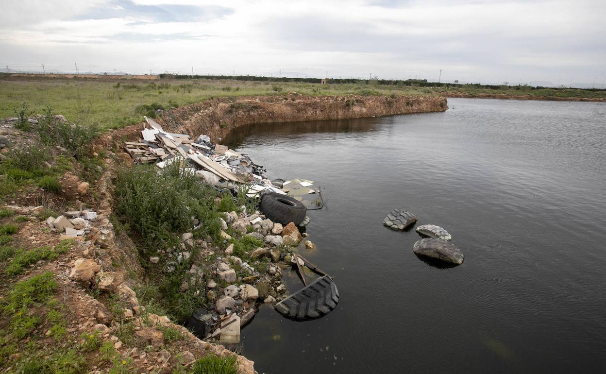Agua depurada vertida en un terreno excavado en Los Camachos, entre escombros y neumáticos viejos.