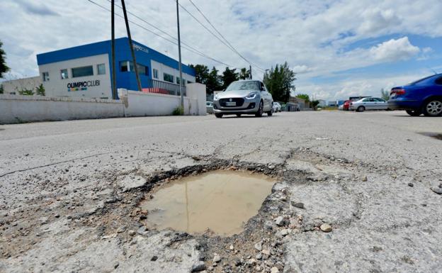 Socavón cubierto de agua.Bache en la Senda de Granada, junto a la Avenida Reino de Murcia. 