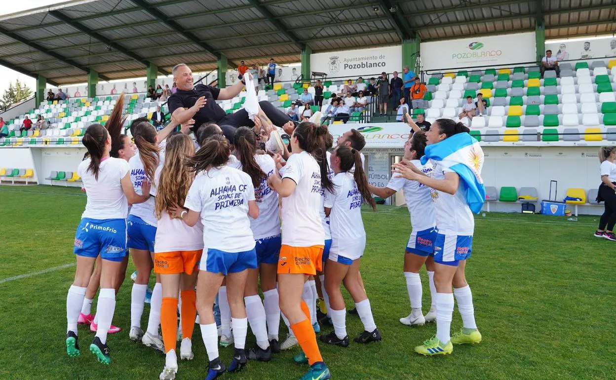 Jugadoras, técnicos y aficionados y aficionadas del Alhama celebran ayer en el campo el ascenso del equipo a la máxima categoría del fútbol femenino.