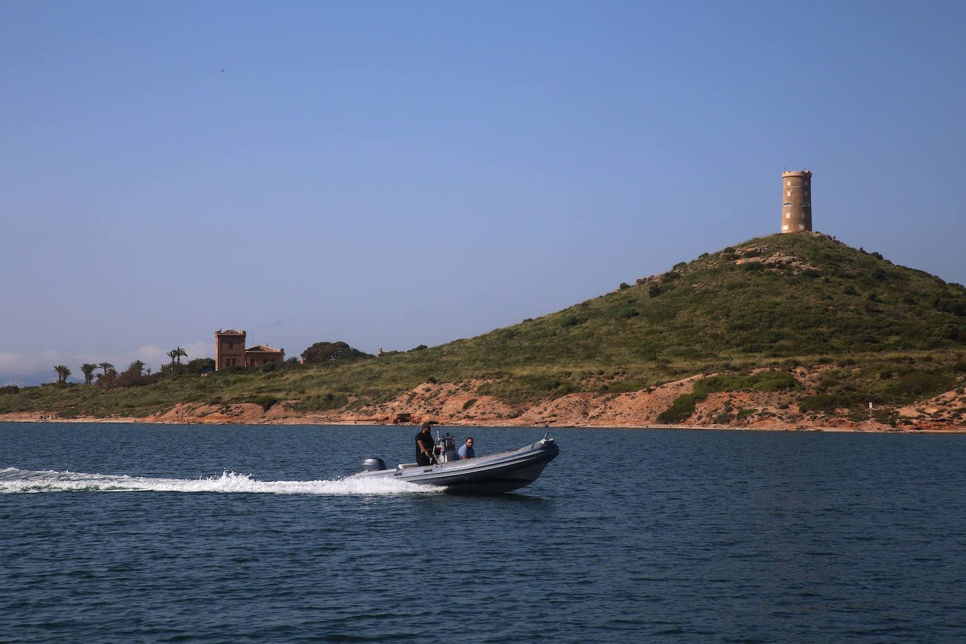 Una lancha navega por el Mar Menor frente a la Isla del Barón. 