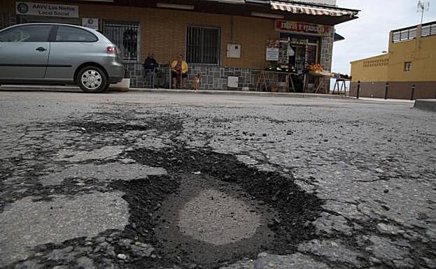 Socavón y asfalto resquebrajado en la plaza de los Cuatros Santos.