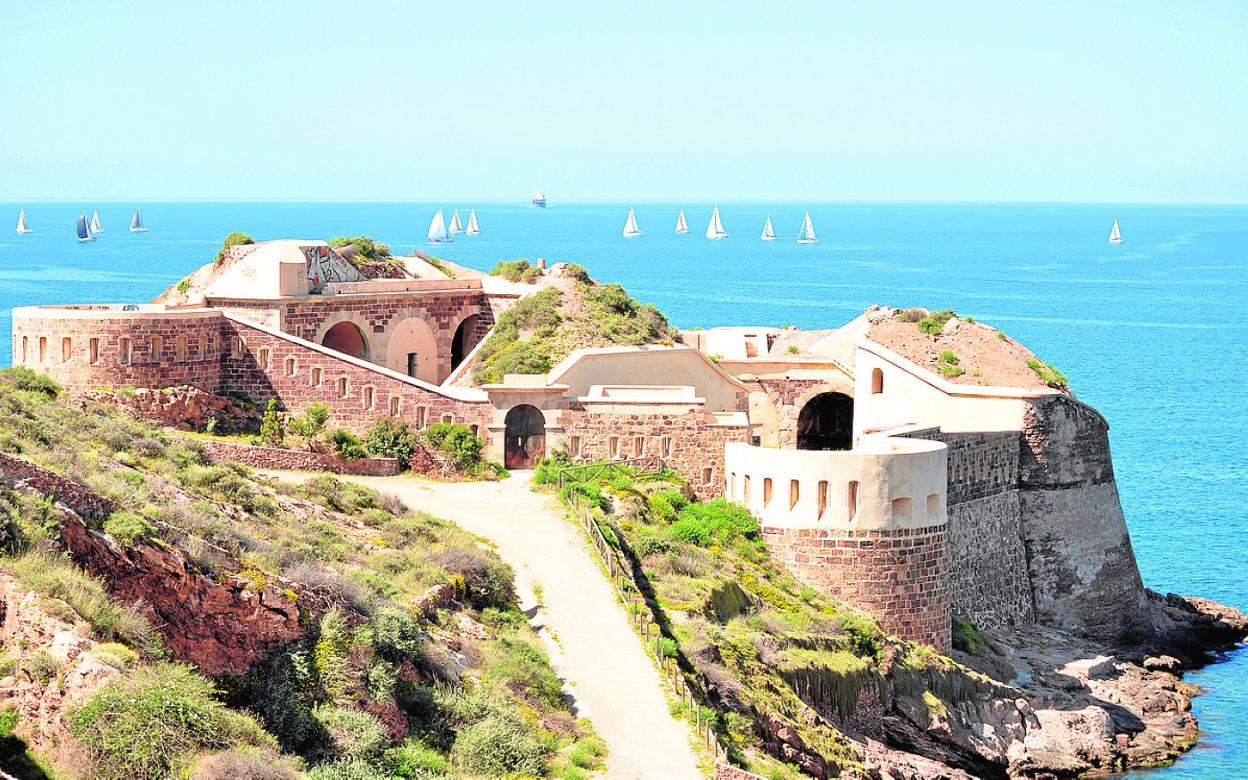 Los barcos participantes en la regata se alejan del Puerto, con la batería de Santa Ana y Santa Florentina (Cala Cortina) en primer término. 