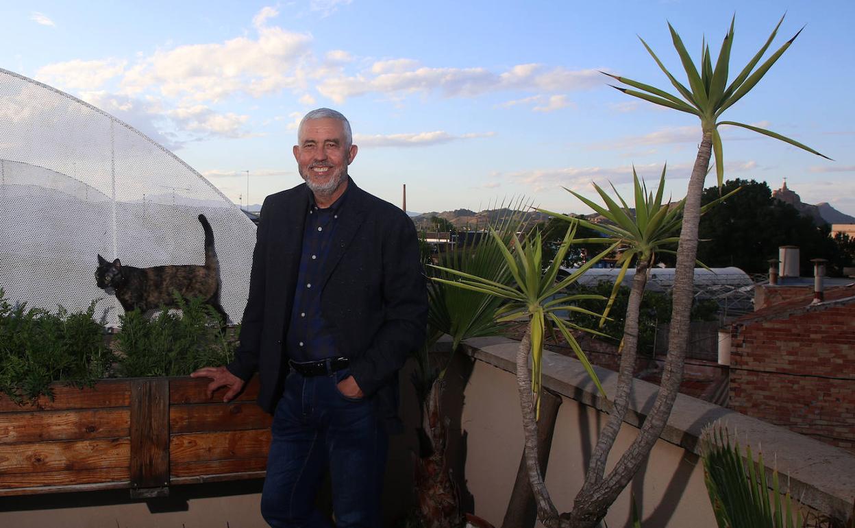 El profesor y crítico literario de LA VERDAD, José Belmonte, con su gata Tula en la terraza de su casa, en Murcia. 