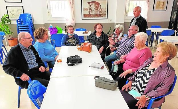 Un grupo de vecinos, hablando sobre los suelos en el local social del barrio.