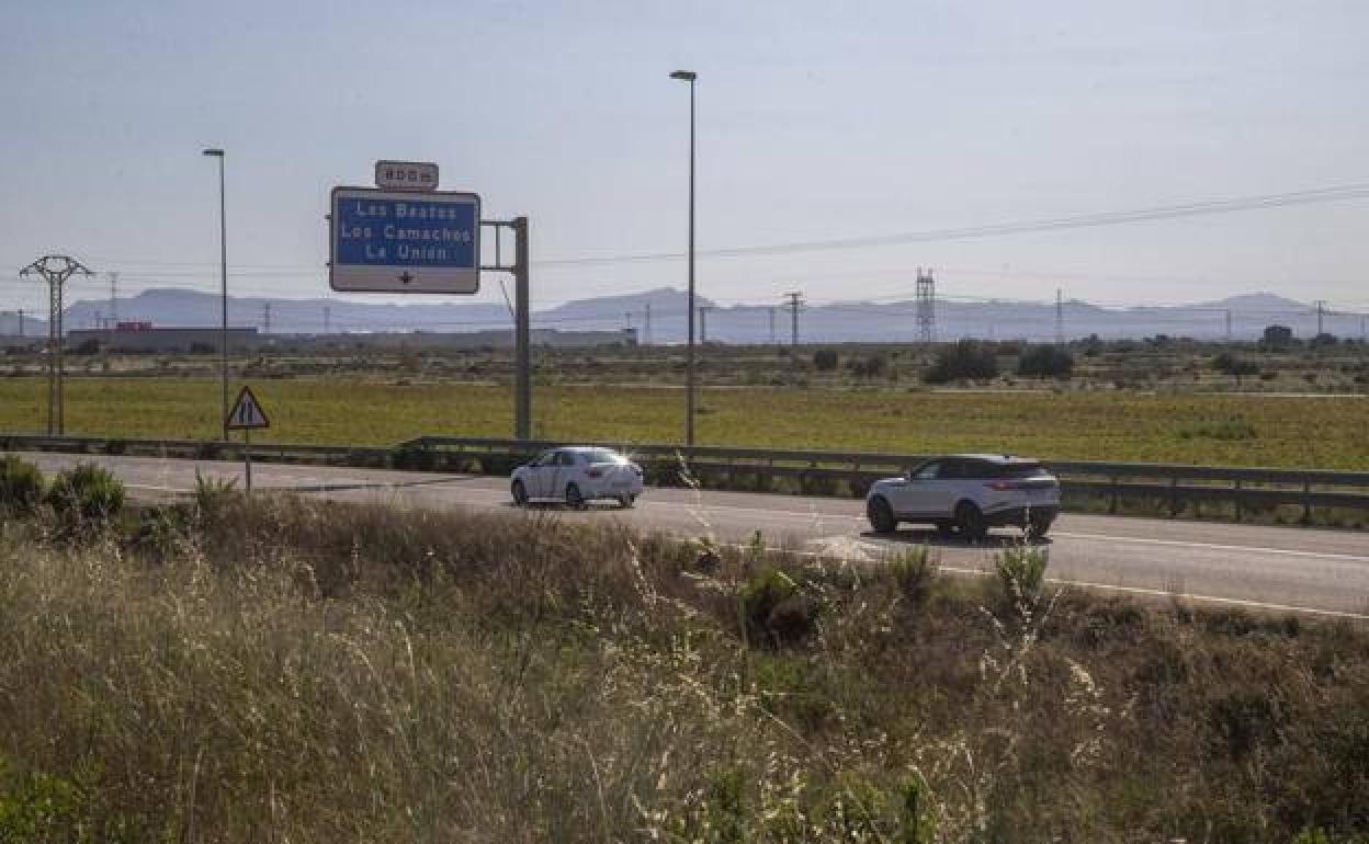 Dos vehículos circulan por la autovía, junto a los terrenos adquiridos por el Puerto para la ZAL.