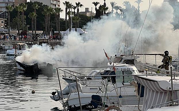 Incendio originado en un barco ubicado en el muelle pesquero de Águilas, este lunes.