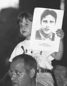 Imagen secundaria 2 - Arriba: Miradas perdidas, aplausos para Miguel Ángel en Murcia. Abajo: paro en la ciudad de Murcia en recuerdo del edil asesinado y una niña en brazos con una fotografía de Miguel Ángel Blanco. 