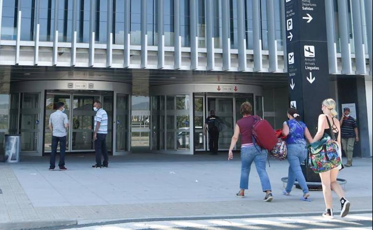 Varias personas entrando al aeropuerto.