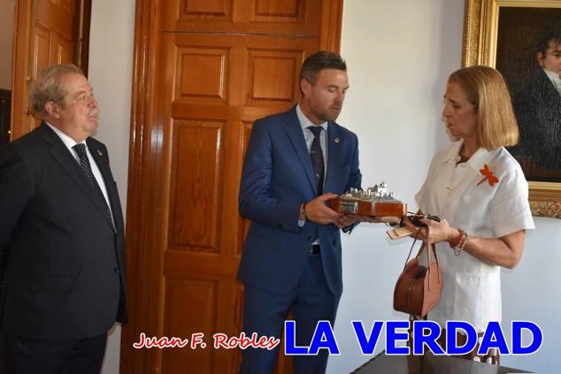 La Infanta Elena fue recibida por el alcalde de Caravaca, José Francisco García, en el Ayuntamiento; saludó a los concejales de la Corporación Municipal y firmó en el libro de honor del consistorio. El regidor caravaqueño entregó a doña Elena una maqueta del castillo-basílica de la Vera Cruz bañada en plata y varios pares de alpargatas de yute fabricadas en una fábrica caravaqueña. La misma que también ha servido este producto artesanal a la Reina Letizia y a Doña Sofía.