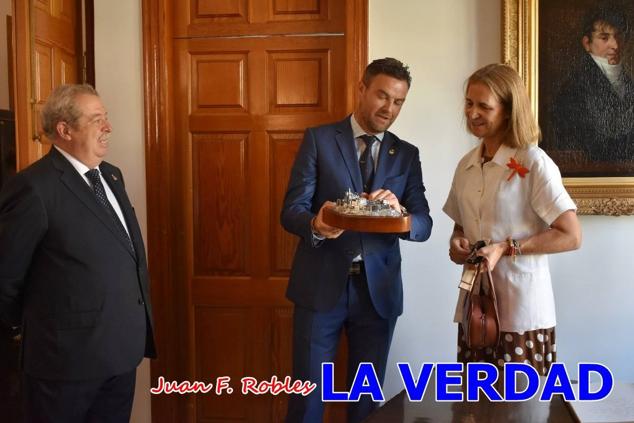 La Infanta Elena fue recibida por el alcalde de Caravaca, José Francisco García, en el Ayuntamiento; saludó a los concejales de la Corporación Municipal y firmó en el libro de honor del consistorio. El regidor caravaqueño entregó a doña Elena una maqueta del castillo-basílica de la Vera Cruz bañada en plata y varios pares de alpargatas de yute fabricadas en una fábrica caravaqueña. La misma que también ha servido este producto artesanal a la Reina Letizia y a Doña Sofía.