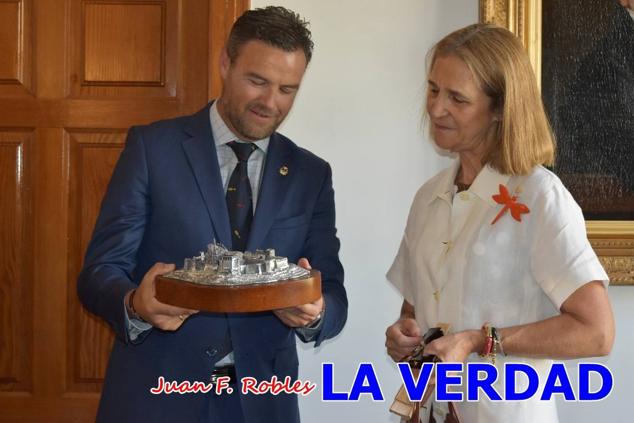 La Infanta Elena fue recibida por el alcalde de Caravaca, José Francisco García, en el Ayuntamiento; saludó a los concejales de la Corporación Municipal y firmó en el libro de honor del consistorio. El regidor caravaqueño entregó a doña Elena una maqueta del castillo-basílica de la Vera Cruz bañada en plata y varios pares de alpargatas de yute fabricadas en una fábrica caravaqueña. La misma que también ha servido este producto artesanal a la Reina Letizia y a Doña Sofía.
