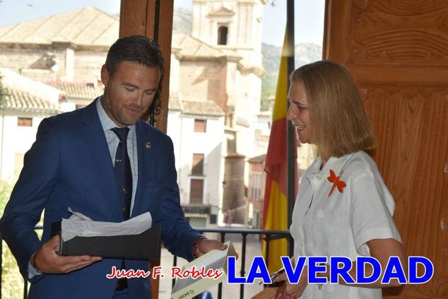 La Infanta Elena fue recibida por el alcalde de Caravaca, José Francisco García, en el Ayuntamiento; saludó a los concejales de la Corporación Municipal y firmó en el libro de honor del consistorio. El regidor caravaqueño entregó a doña Elena una maqueta del castillo-basílica de la Vera Cruz bañada en plata y varios pares de alpargatas de yute fabricadas en una fábrica caravaqueña. La misma que también ha servido este producto artesanal a la Reina Letizia y a Doña Sofía.