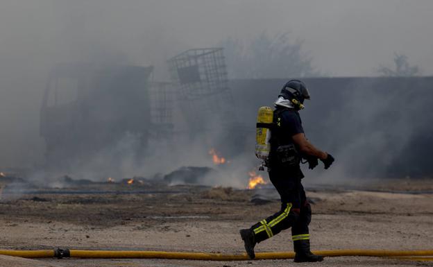 Imagen de uno de los bomberos durante las labores de extinción del incendio este sábado en una nave de Pozo Estrecho. 