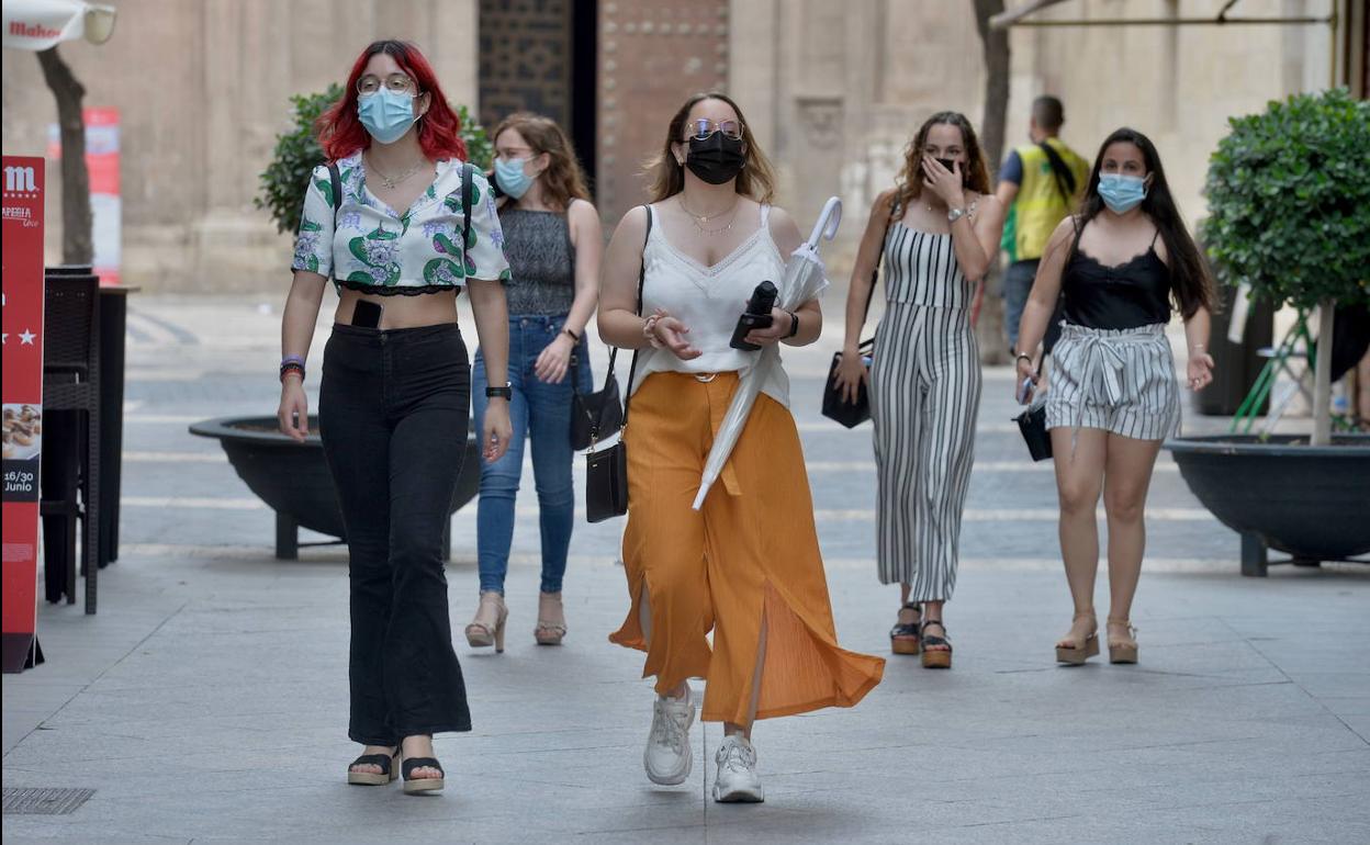 Jóvenes con mascarilla paseando por el centro de Murcia, en una foto de archivo.