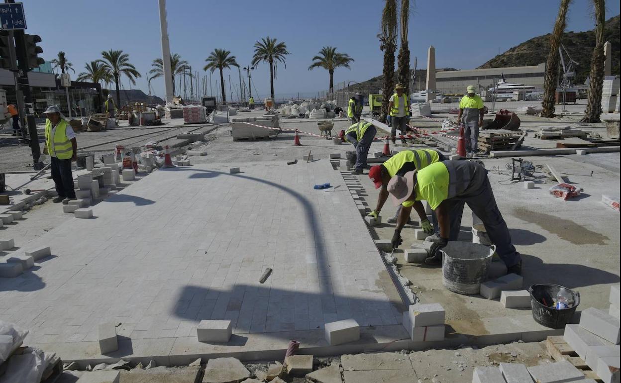 Un grupo de operarios colocan adoquines en la explanada más próxima a la Escala Real.